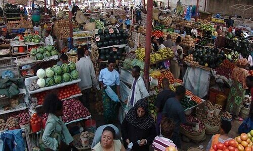 Traders at a busy indoor produce market in Arusha